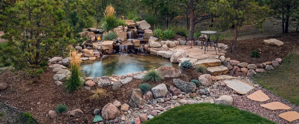 Backyard pond with waterfall and natural stone landscaping