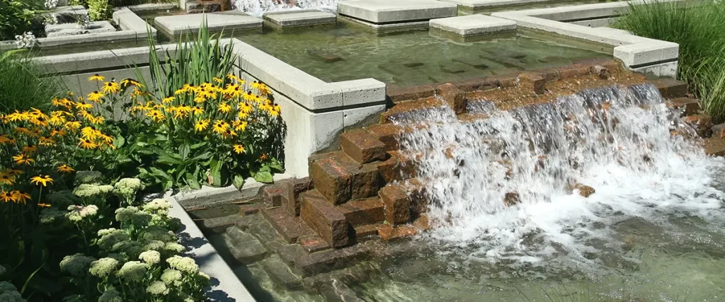 Modern water feature with cascading stone steps and flowers