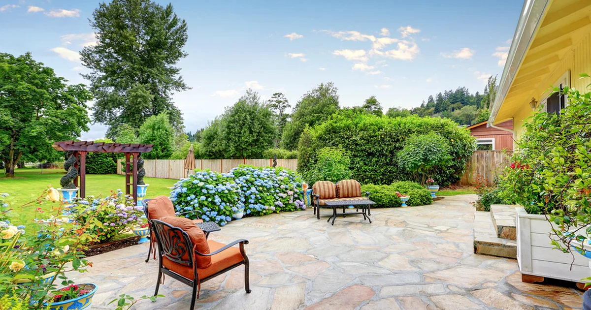 spacious paver patio with professional landscaping lush greenery and elegant outdoor seating