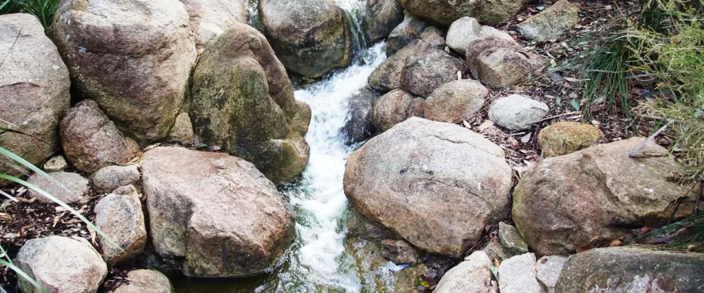 Close-up of water flowing through rocks in a natural-style pondless waterfall stream