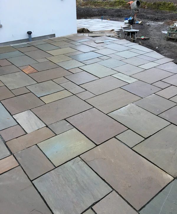A wide-angle view of a large natural stone paver patio featuring various earthy tones installed at a residential property in Central Florida, ready for paver sealing.